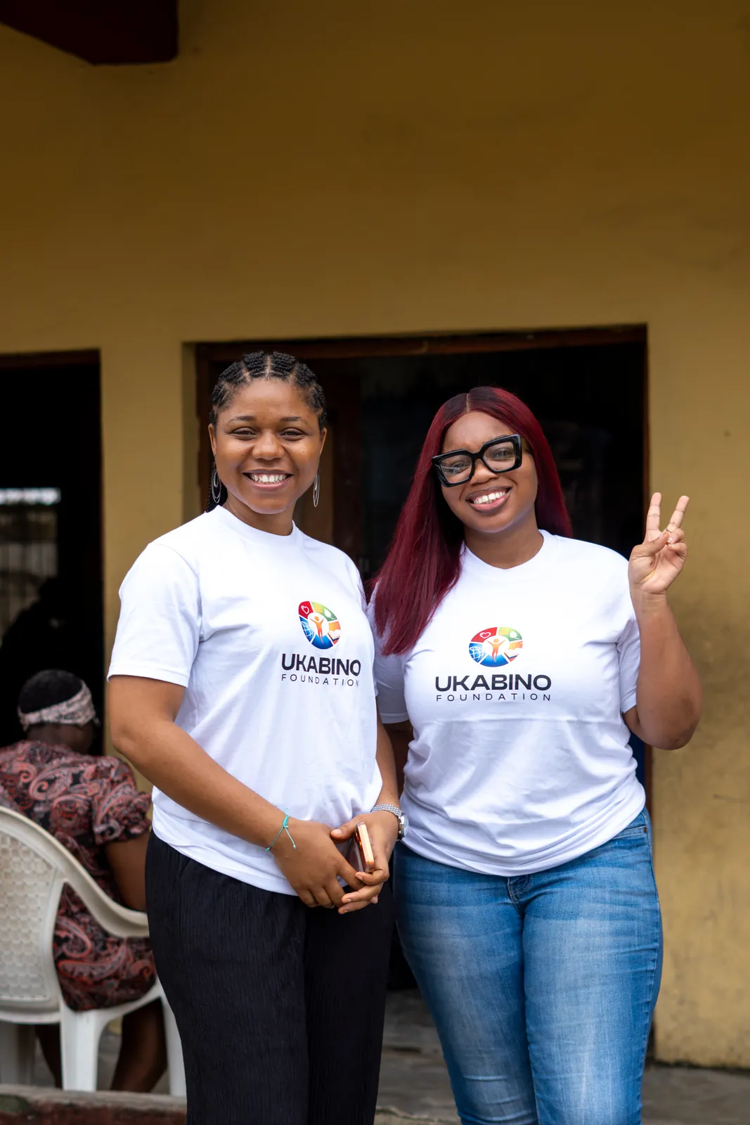 Two Ukabino volunteers smiling outside the programme venue
