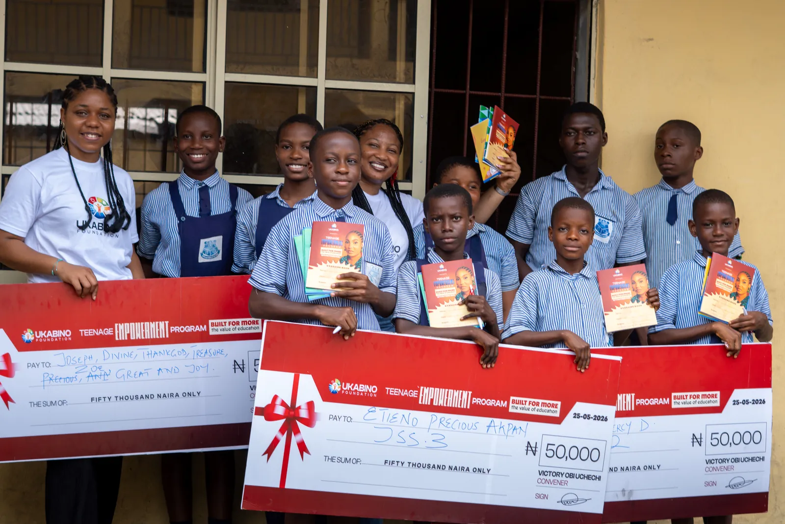 Students and programme guests displaying support cheques