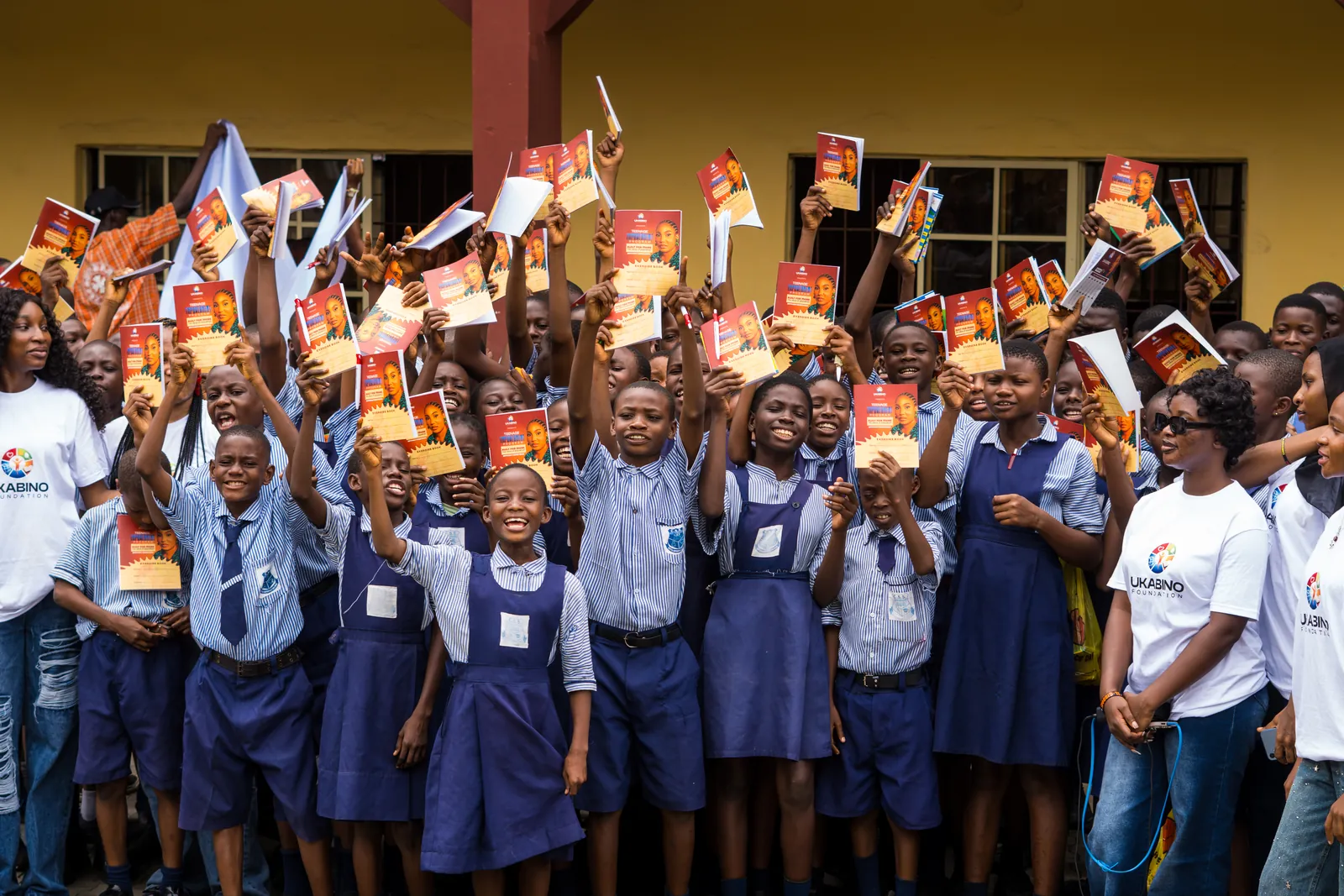Students celebrating with books after the programme