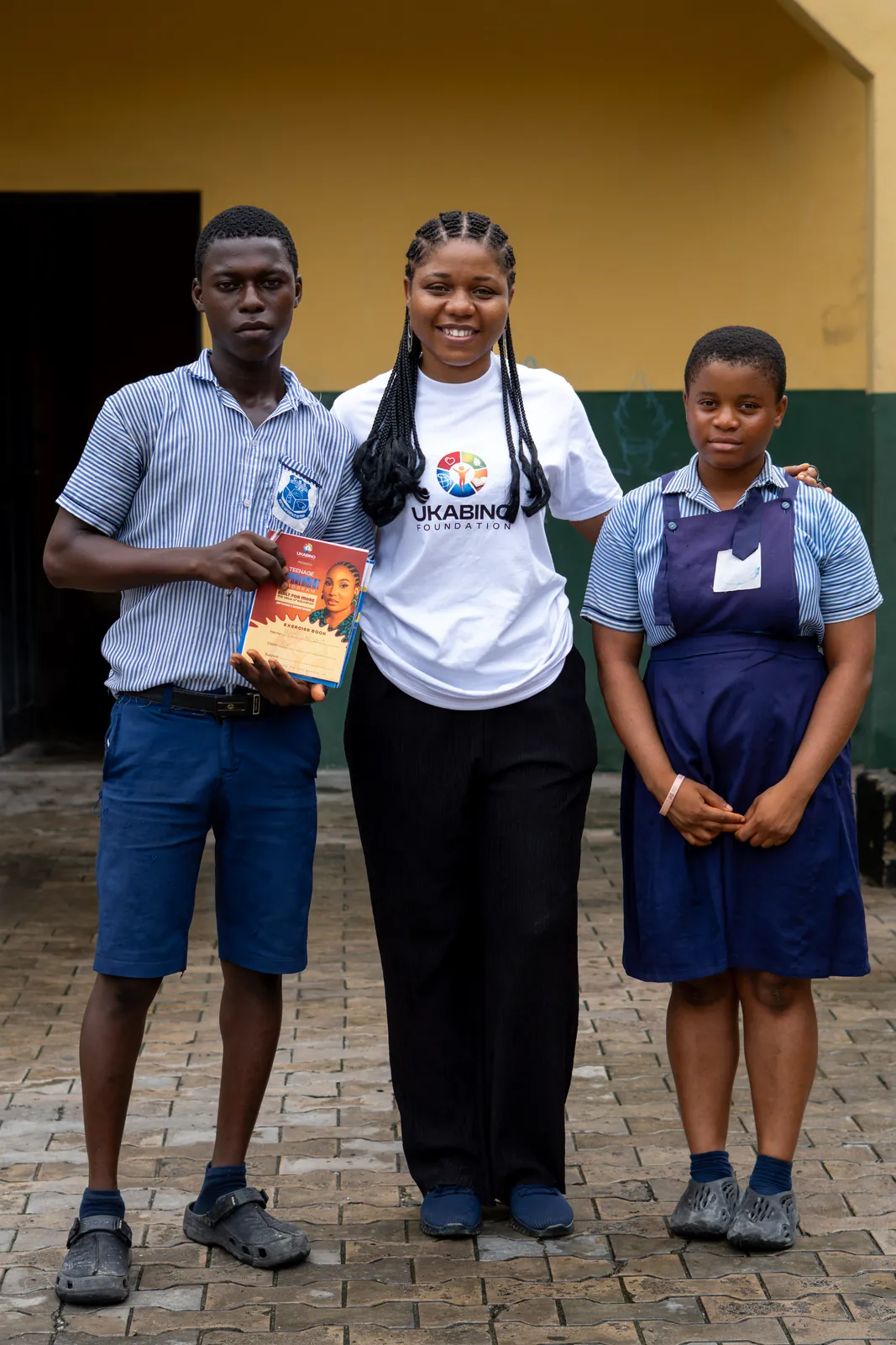 Students holding books with Ukabino volunteers